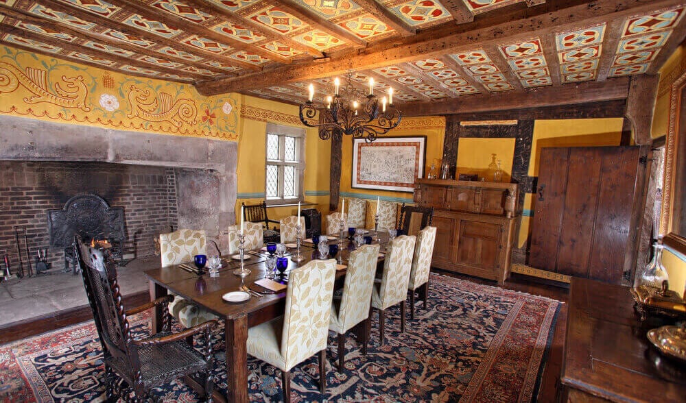 Christmas Cottages: Upton Cressett Hall spectacular Great Hall dining room with an enormous stone fireplace and a unique Tudor hand-painted ceiling